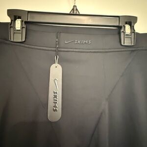 SKIMS Black Leggings. 

NikeSKIMS SHINE V-LINE 26" LEGGING | OBSIDIAN